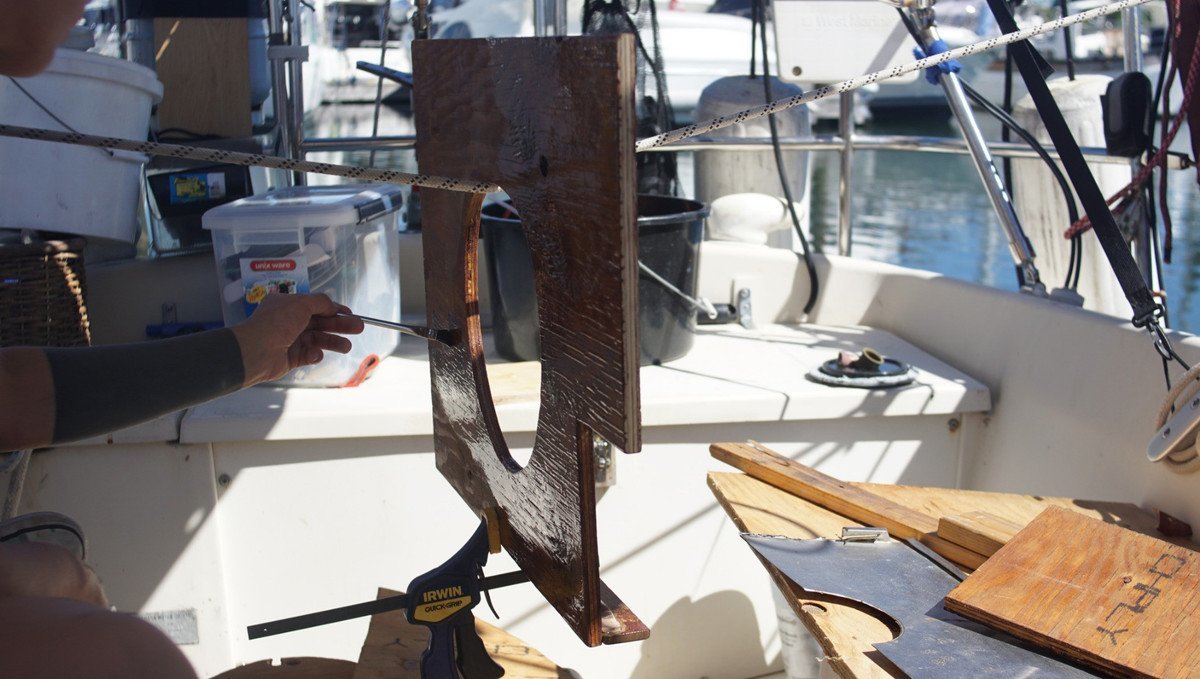 A photo of a piece of wood with someone applying a fresh coat of epoxy