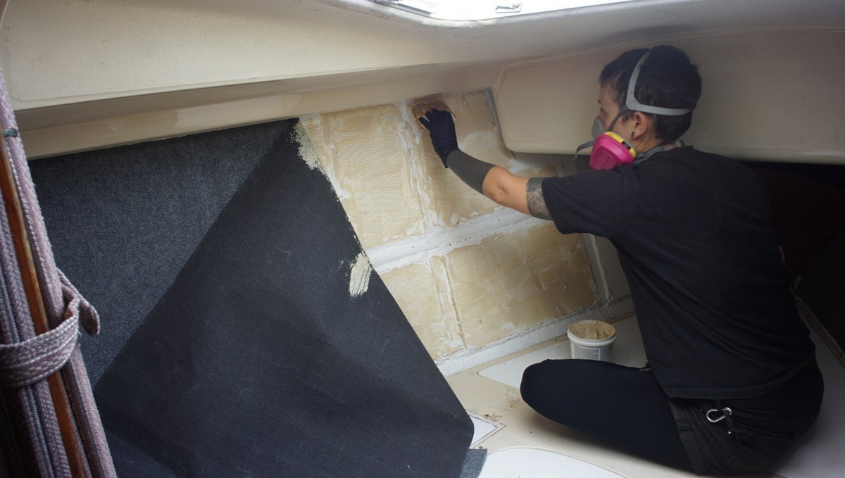 rek applying glue to the wall for the carpet