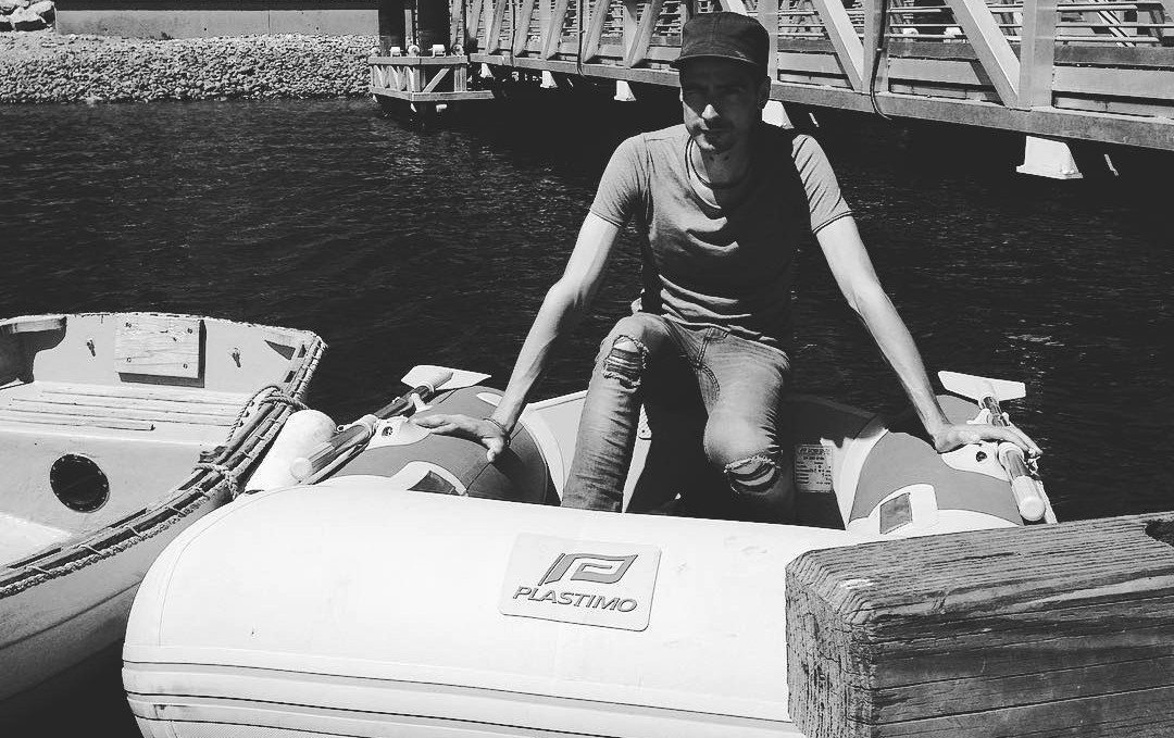 Devine is sitting inside Iggy at a dinghy dock