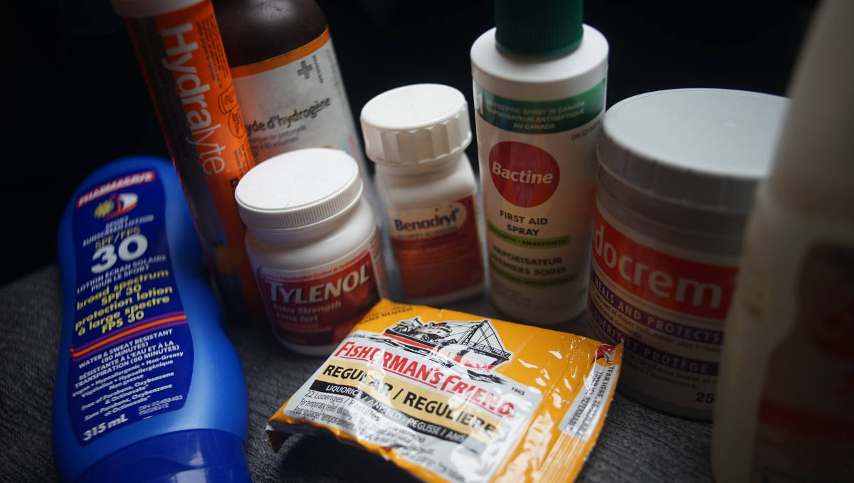 a photo featuring items from a medicine kit like sunscreen, benadryl, insect repellant, tylenolt, fisherman's friend, bactine, sudocrem, hydralite, and hydrogen peroxide.