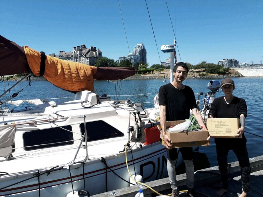 rek and devine holding boxes of fresh produce