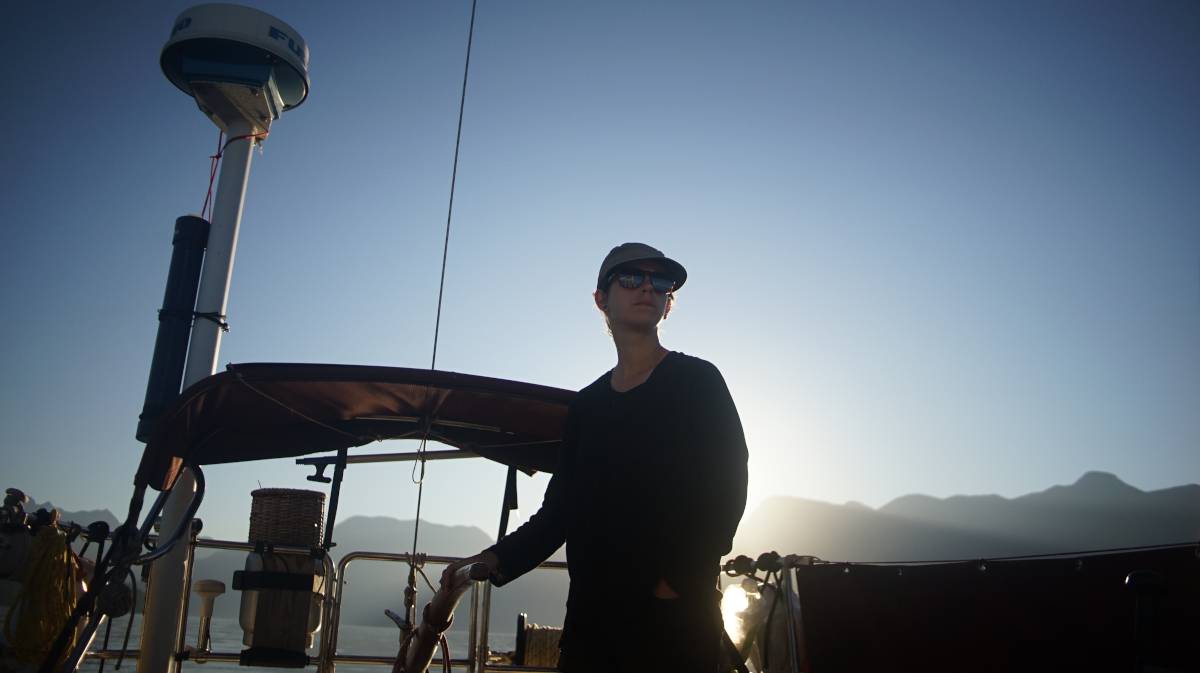 rek steering early in the morning, sunrise peeking over the mountains in the background