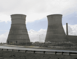 Dust and debris rise as large concrete cooling towers collapse during a controlled demolition