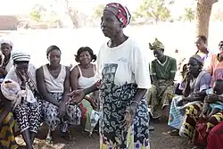 Traditional midwife in Africa at a community meeting, explaining the dangers of cutting for childbirth