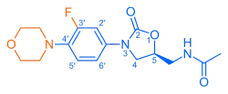 Skeletal formula of N-{[(5S)-3-[3-fluoro-4-(morpholin-4-yl)phenyl]-2-oxo-1,3-oxazolidin-5-yl]methyl}acetamide, highlighting the morpholino and fluoro groups in orange, with the rest in blue. The carbon atoms of the parent chain are numbered.