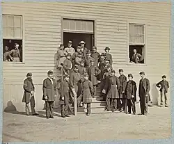 a group of hospital stewards and surgeons in uniform standing outside of a hospital.