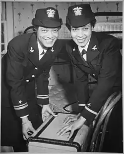 Two African-American WAVE officers in dress uniforms shutting a suitcase