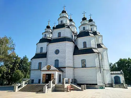 Nine-domed wooden church with white walls and black roof