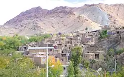 Photo of a small village consisting of basic dwellings built along a hillside.