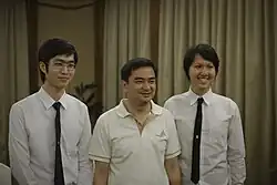 Chulalongkorn students wearing male university uniforms with former Prime Minister Abhisit Vejjajiva.