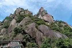 Granite rock formations partially covered by trees