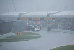The area is saturated with heavy rain and all cars are stopped behind the safety car.