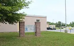 A pink brick wall with a stone sign in front of it reading "Calvert High School, Home of the Cavaliers, Student Council 1982–83