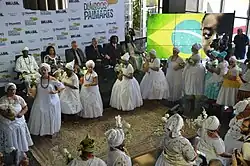 Women in white dresses in a semi-circle
