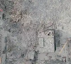 Site of 4 WTC in NOAA aerial image, oriented with south at left of image (September 23, 2001). Much of 4 WTC is destroyed (entire left of image), with only the damaged northern portion identifiable (at right).