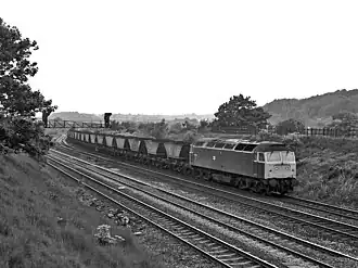 A black and white image of a train hauling freight wagons