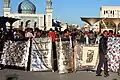 A protest outside the mosque, with the people flashing banners that indicate this protest is only for cultural and not religious purposes