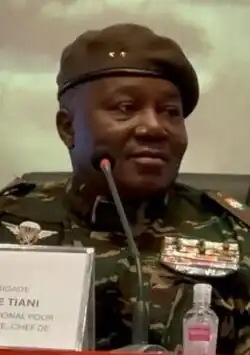 Headshot of a seated Tchiani looking right