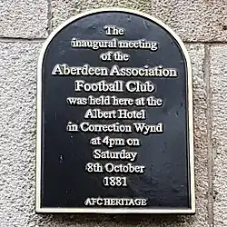 A black plaque with the text "the inaugural meeting of the Aberdeen Association Football Club was held here at the Albert Hotel in Correction Wynd, at 4pm on Saturday 8th October 1881. AFC Heritage"