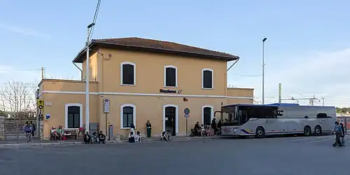 Two-story building with one-story wings and hipped roof