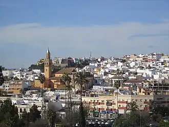 View of Alcalá de Guadaíra showing white residential buildings and a church tower