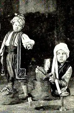 Still for the American film Ali Baba and the Forty Thieves with Ali Baba (George Stone) being asked by his rich brother the secret of the cave, from pages 16 and 17 of the February 1919 Film Fun