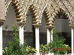 Polylobed arches in the Mudéjar-style Patio de las Doncellas at the Alcazar of Seville in Spain (14th century)