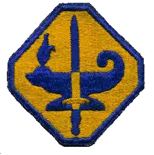 Photograph of the blue and gold octagon-shaped insignia patch for the Army Specialized Training Program (ASTP), featuring an oil lamp and sword at its center