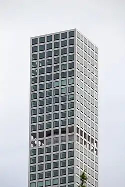 The top stories of 432 Park Avenue. There are windows on each story, except near the bottom of the image, where there is a double-height windbreak with no windows.