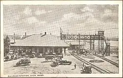 A postcard showing a railway station at a diamond crossing, with signal bridges over the tracks