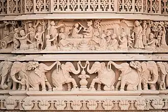 Exterior carving showing Swaminarayan ordaining Gunatitanand Swami, his first spiritual successor