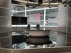 A television news studio overlooking a window between broadcasts.