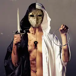 A masked figure, with a keyhole in the middle of its body, wearing a robe that is black on one side and white on the other. It holds up a knife on the black robed side, while a set of keys is held up on the white side.