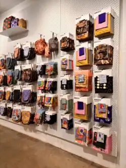 Many bags hanging on a wall in a store display