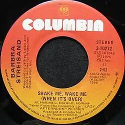 A red-orange vinyl record of the single appears