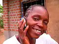 A Basankusu woman celebrates being connected to the outside world by mobile phone with a phone call to relatives in Kinshasa.