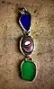 Fordite (center) on a piece of jewelry alongside blue and green beach glass, 2013