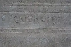 Detail of an engraved stone with a difficult-to-interpret inscription