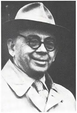 black and white photo of a smiling man wearing a hat
