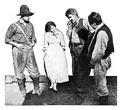 Black and white photograph showing Bessie Love with other cast members in Western period costumes