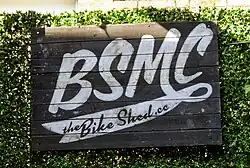 Painted sign with white letters BSMC on a black background