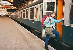 Young woman with a backpack boarding a train