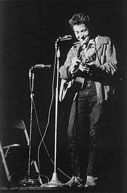 A spotlight shines on Dylan as he performs onstage.