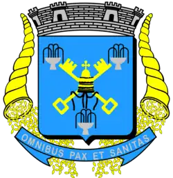 A blue shield with two golden keys beneath a papal tiara, surrounded by three silver fountains; in both sides of it are two cornucopias sprinkling coins; on the top of the shield is a silver mural crown with six towers and in the bottom of the shield is a blue scroll with the sentence Omnibus Pax et Sanitas written on it