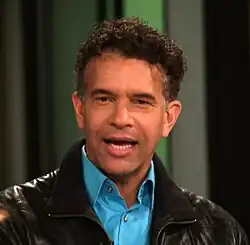 Man wearing a black leather jacket with a baby blue shirt