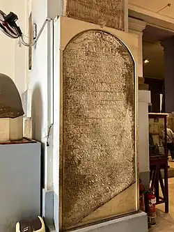 A large stone marker inscribed with Egyptian hieroglyphs. The lower right corner is damaged and partially broken off.