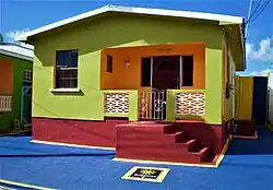 A small house prominently colored in red, green, and orange