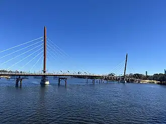 An under-construction cable-stayed bridge across the Swan River with two towers, July 2024