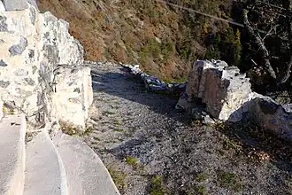 Two separate low walls leading to a corridor.