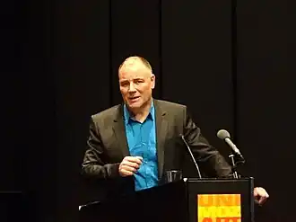 Middle-aged man standing behind a lectern